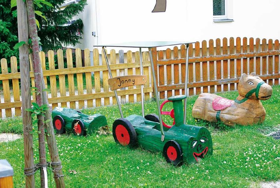 Traktor mit Hänger und liegendes Pferd